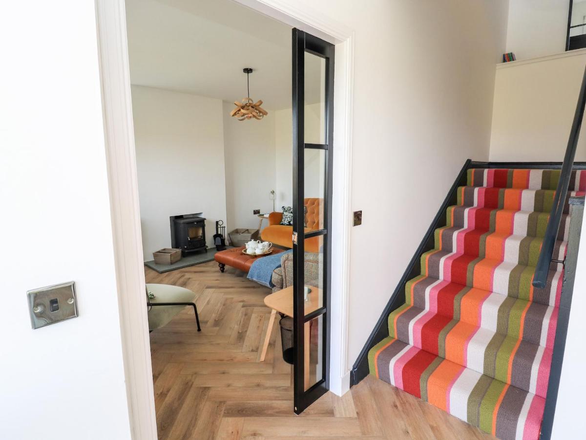 a living room with a staircase and a mirror at Park Cottage in Carinish
