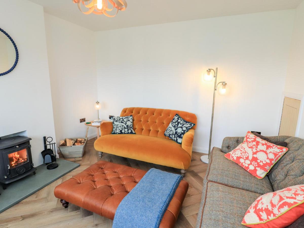 a living room with a couch and a chair at Park Cottage in Carinish